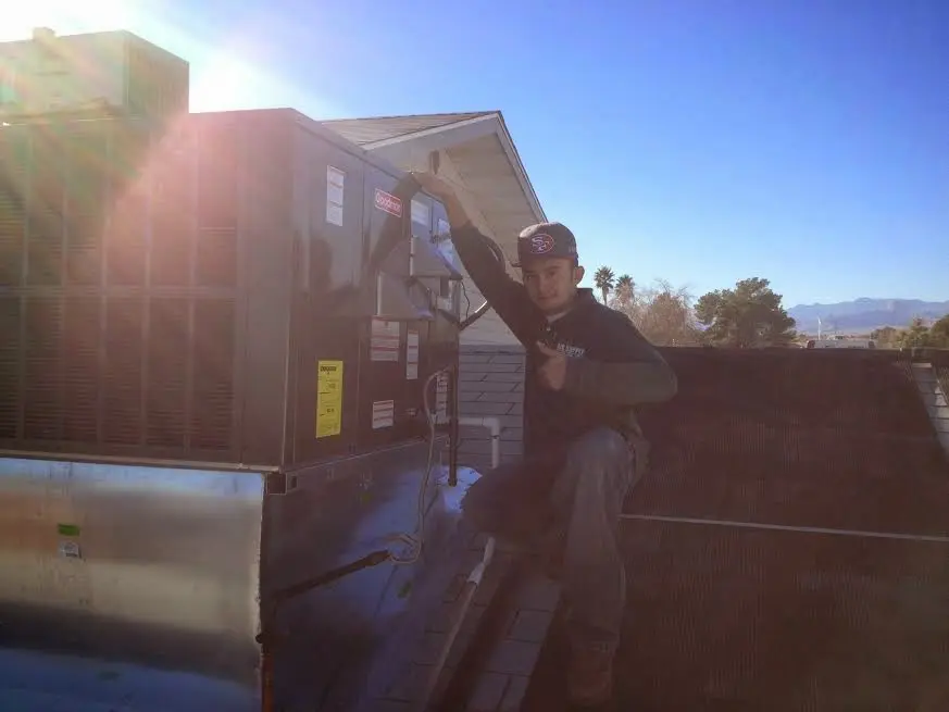 HVAC technician performing AC Tune-Up on a rooftop unit in Campton Hills